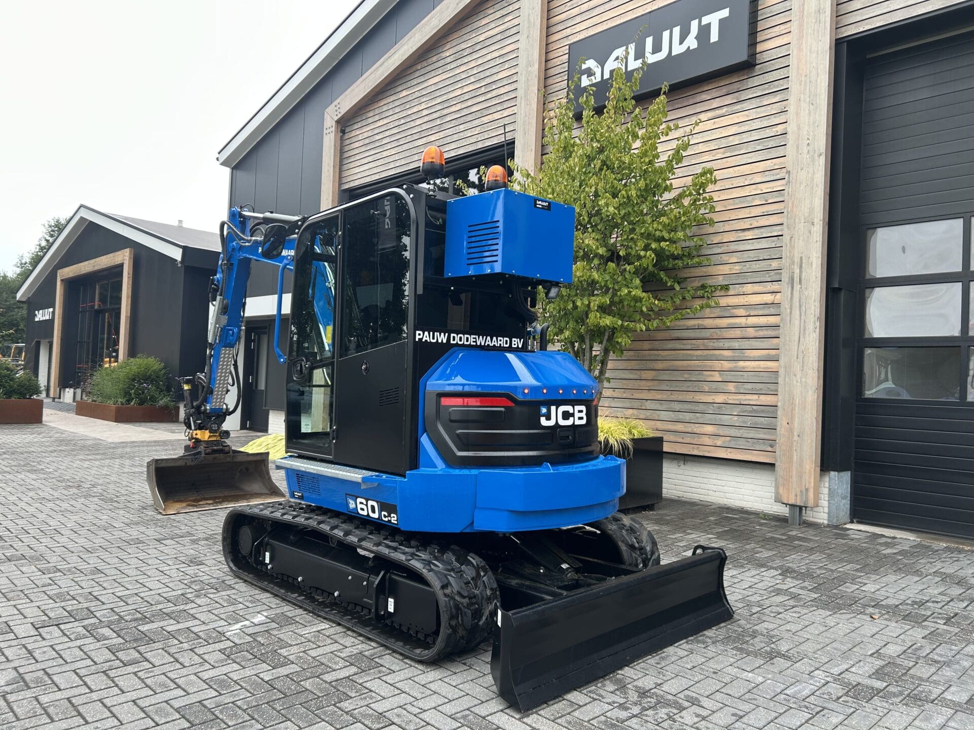 Achteraanzicht van de JCB 60C-2 met extra contragewicht en rode contourverlichting